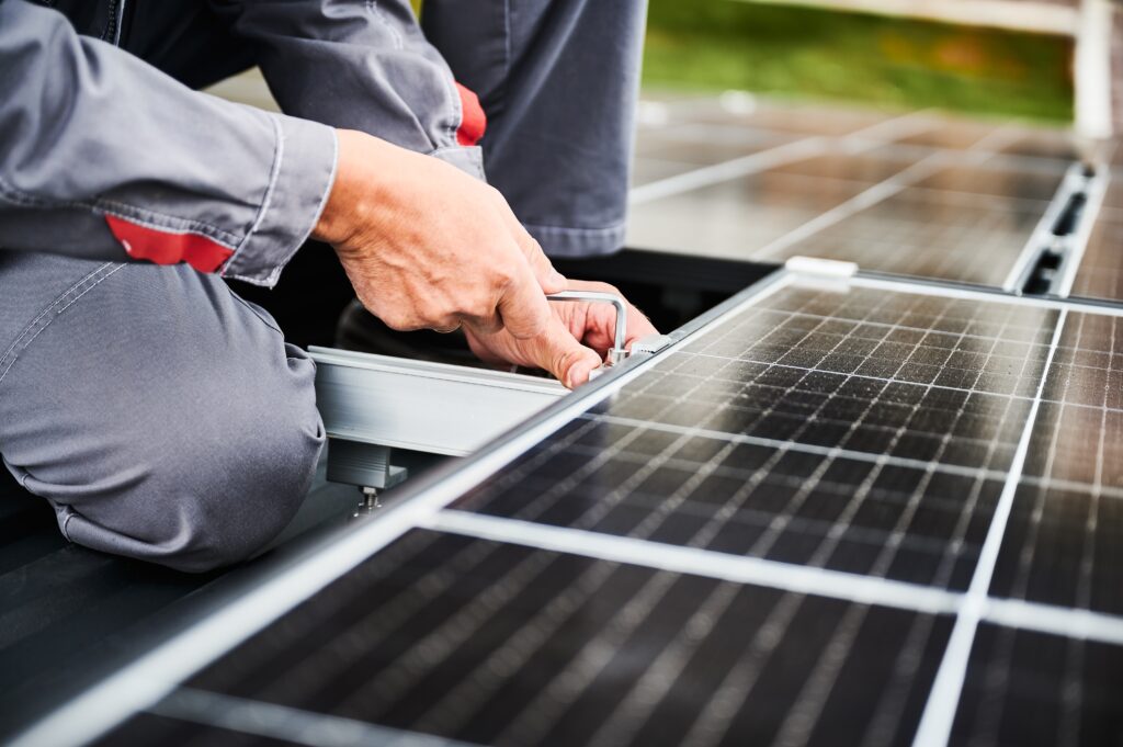 Man,Technician,Mounting,Photovoltaic,Solar,Panels,On,Roof,Of,House.